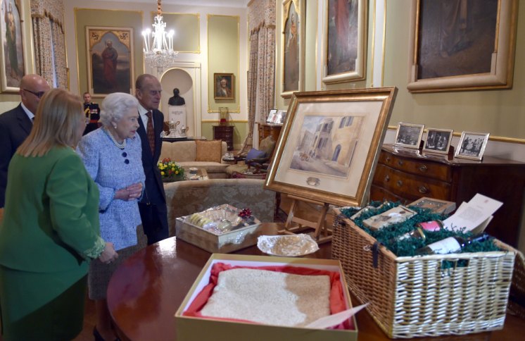 The Queen and The Duke of Edinburgh with the President of Malta, and their gifts, including a painting of their former home.  Picture by i-Images