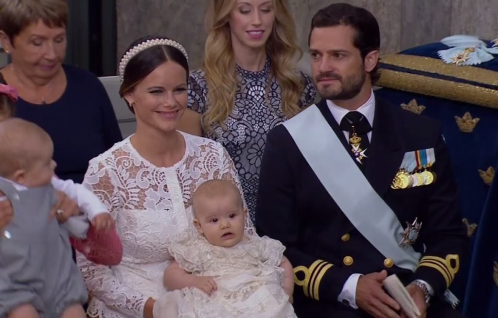 Proud Princess Sofia holds Prince Alexander at his christening today, sitting by her husband, Price Carl Philip (SVT/Kungahuset)